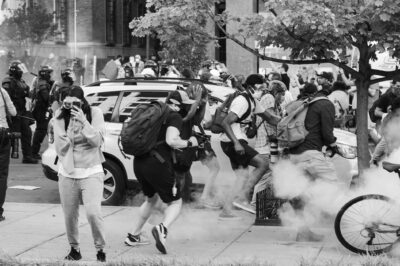 Black Lives Matter Protestors run as tear gas is dispensed into the crowd.