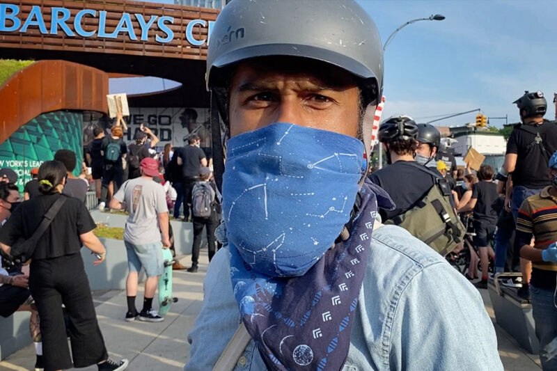 A protester wearing a bandana over their mouth in front of Brooklyn's Barclays Center.