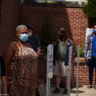 Voters wearing face masks as a preventive measure wait in a line during an early voting in Monroe County, Indiana.