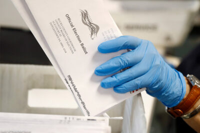 A worker processes mail-in ballots.
