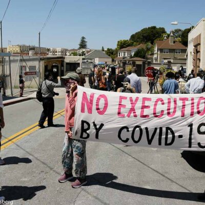 A sign reading "No Executions by Covid-19" is seen at a protest