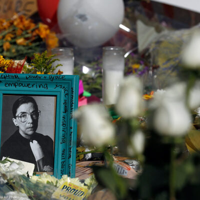 Flowers and a poster with an image of late Associate Justice Ruth Bader Ginsburg are placed outside the Supreme Court in Washington, DC