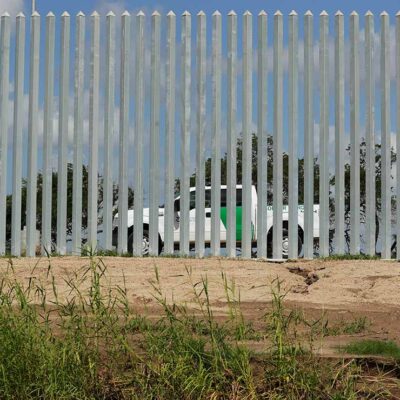 A CBP truck is seen through a border wall