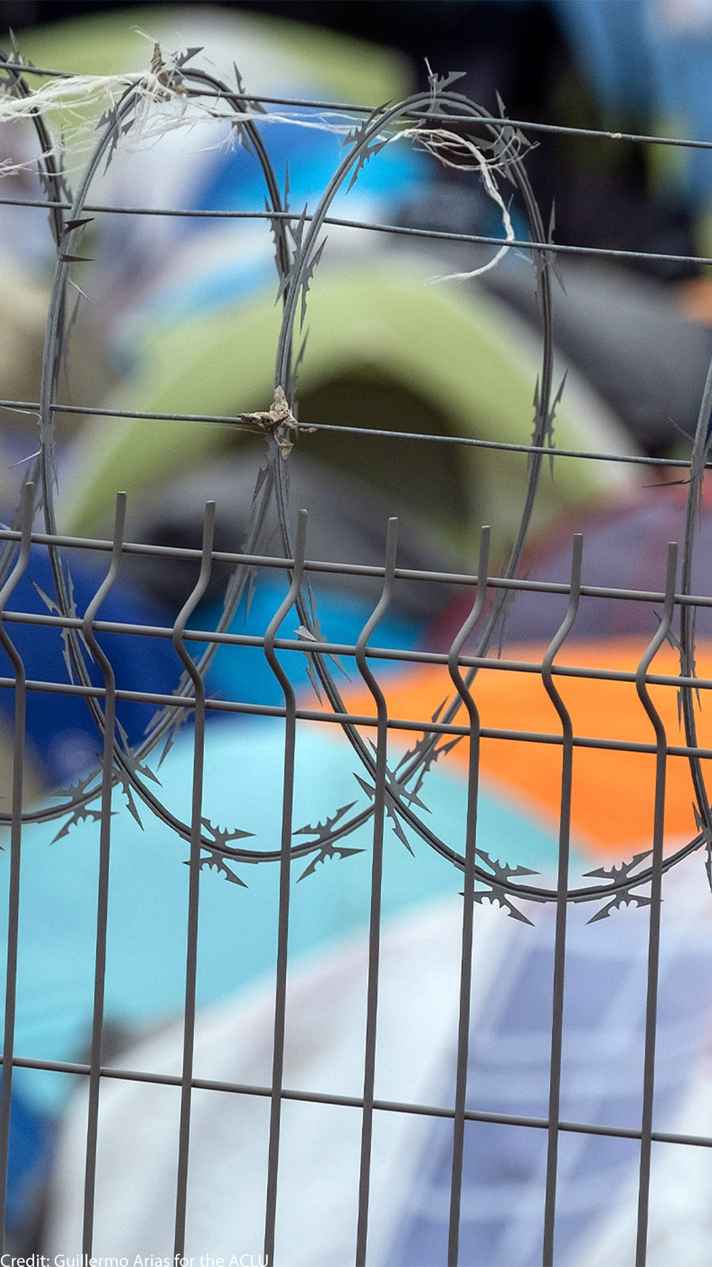 Barbed wire fence at a refugee camp for migrants and asylum seekers in Matamoros, Mexico, October 2019. Guillermo Arias for the ACLU.