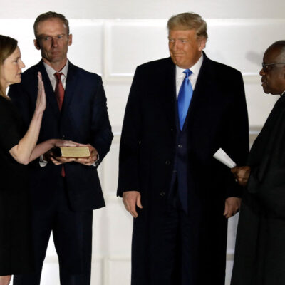 U.S. President Donald Trump smiles as Judge Amy Coney Barrett is sworn in as the Supreme Court associate justice by Justice Clarence Thomas on South Lawn of White House.
