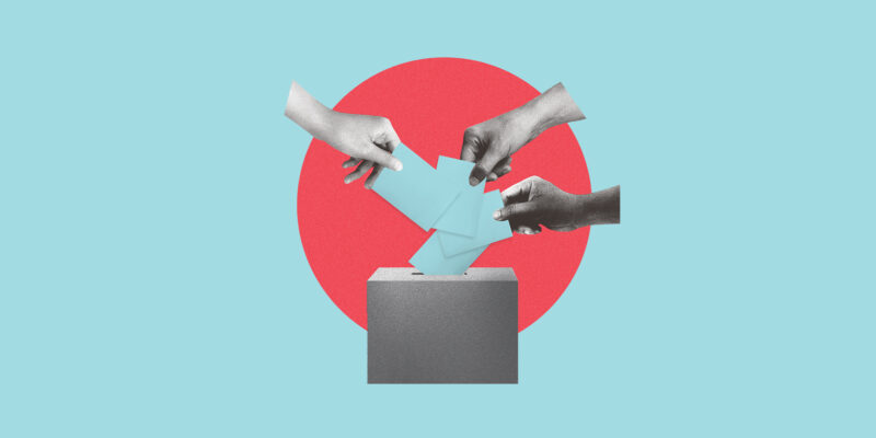 An image of hands casting ballots in a box