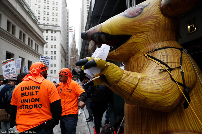 A giant inflatable rat stands in front of a non-union worksite where union workers protested during a May Day rally