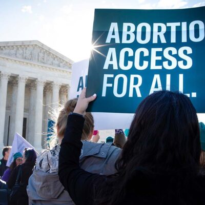 A protestor holds aloft a sign that says "Abortion Access for All" in front of the Supreme Court building in Washington, DC