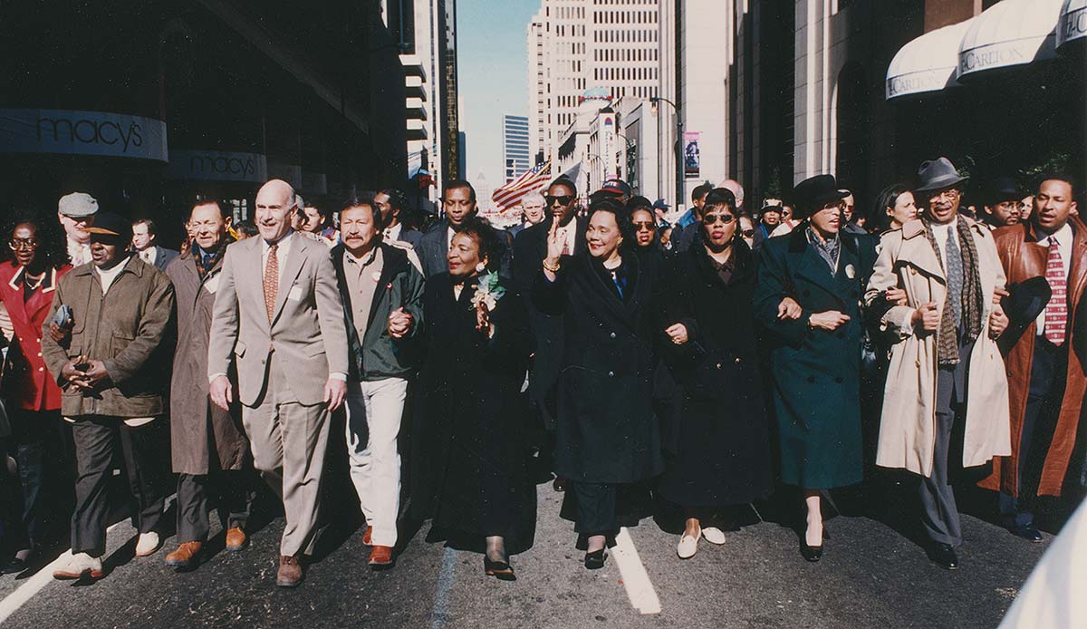 Ira Glasser (at left in beige suit) marching in Atlanta, GA, with Coretta Scott King (center) and others in 1997 Martin Luther King, Jr. Day parade. (Credit: photographer unknown, Studio III: 1021 Northside Drive, Atlanta, GA 30318; 404-875-0161"
