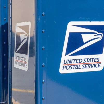 A blue United States Postal Service (USPS) collection box as seen on the street.