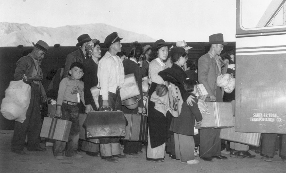 Japanese-Americans transferring from train to bus at Lone Pine, California, bound for war relocation authority center at Manzanar, April, 1942.