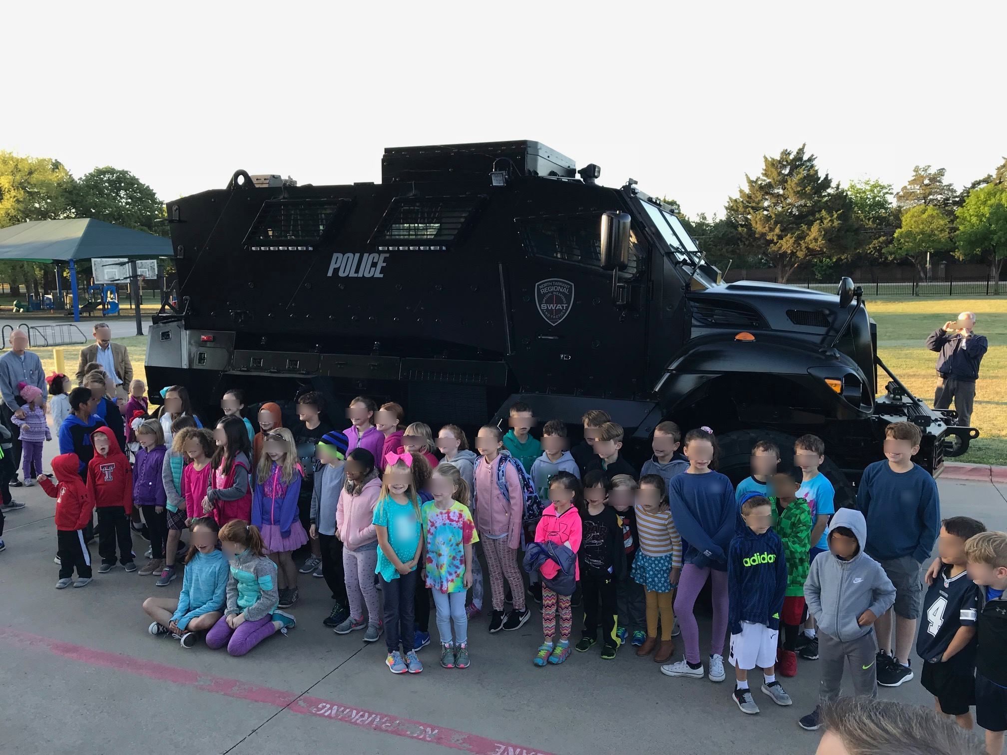 Children pose with a mine-resistant ambush protected vehicle in Southlake, Texas.