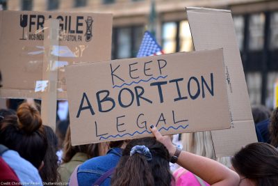 People protesting in support of abortion rights, holding sign that reads "Keep Abortion Legal"