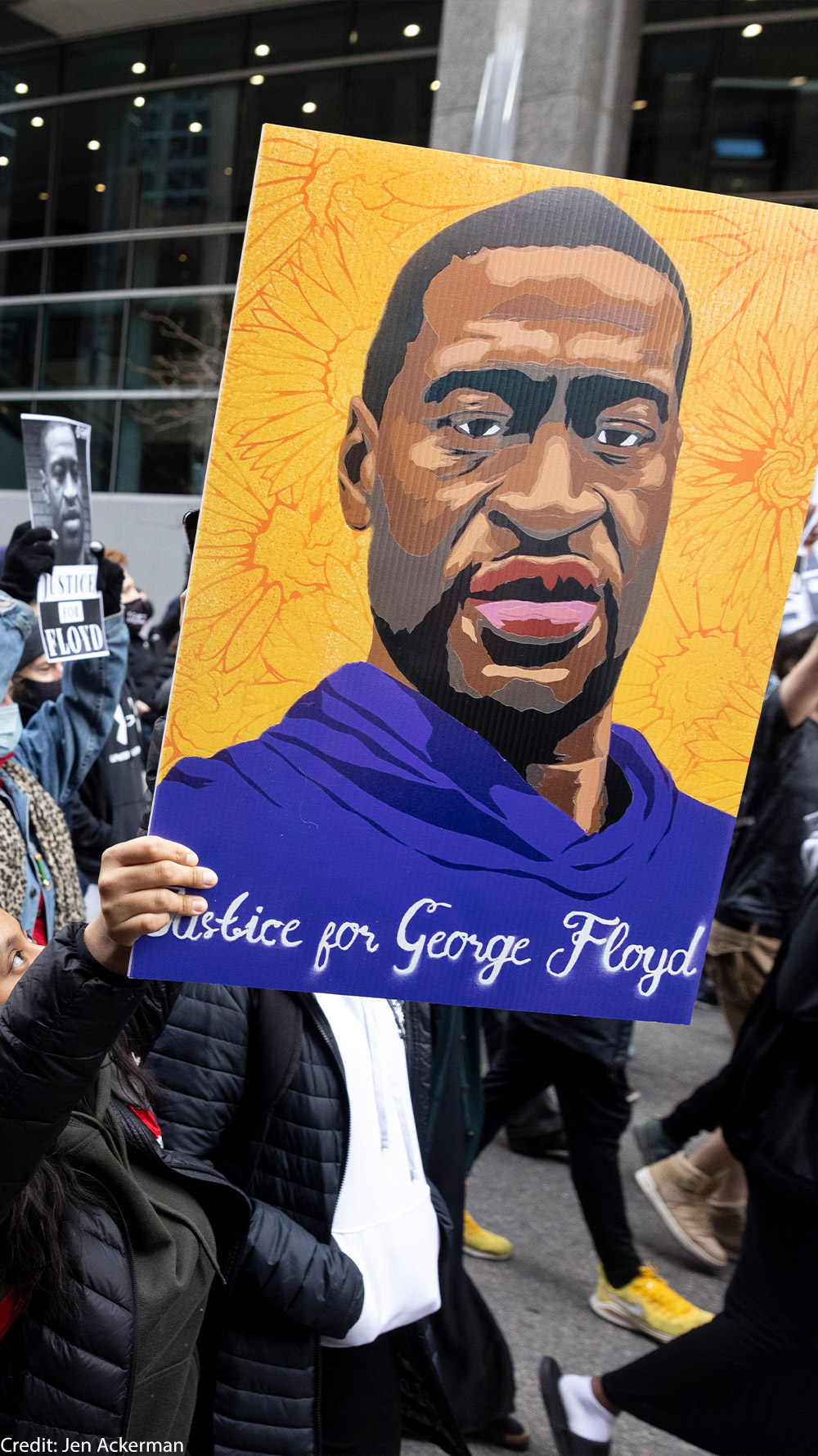 Protestors holding up a portrait of George Floyd