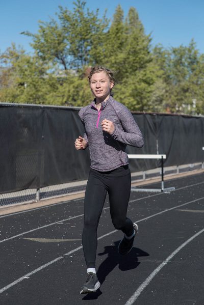 Photo of Lindsay Hecox, a white woman with blonde hair, in workout clothing running on a track.i