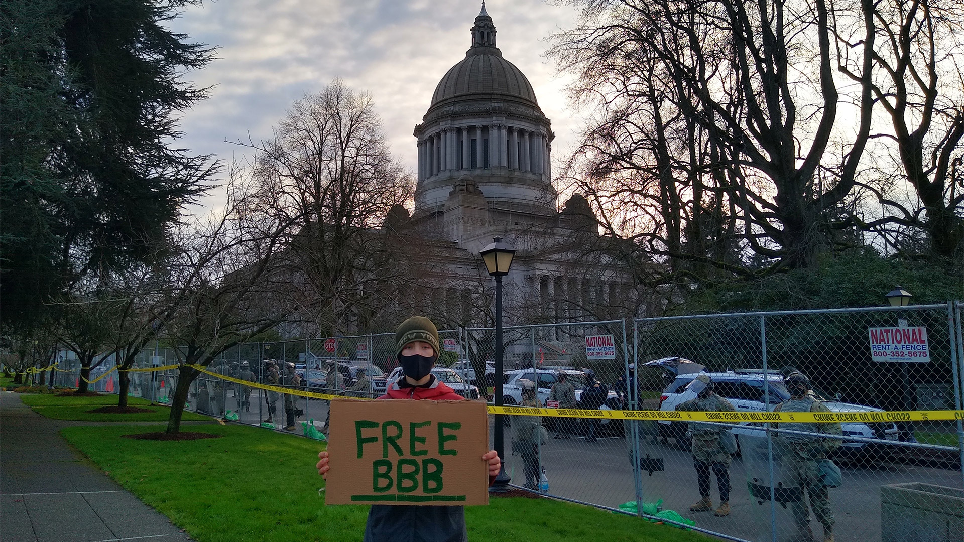 Person holds sign that reads "Free BBB"