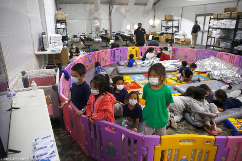 young unaccompanied migrants, from ages 3 to 9, watch television inside a playpen at the U.S. Customs and Border Protection facility