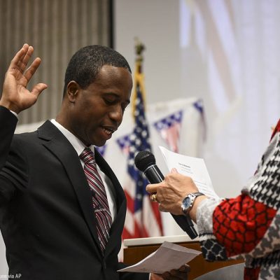 Mike Elliott takes the oath of office as the city's new mayor with city clerk Barb Suciu, right, during Elliot's inauguration ceremony