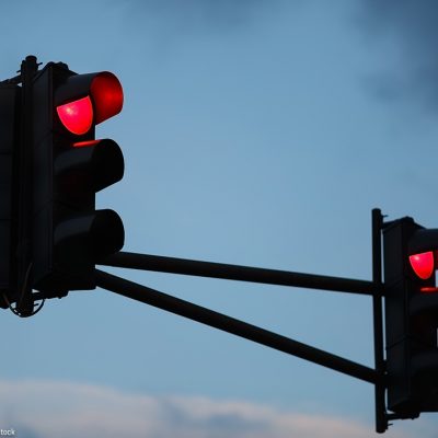 Traffic light with red light against the evening sky. Shallow depth of field.