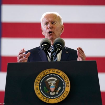 President Joe Biden speaks behind podium to American service members in England