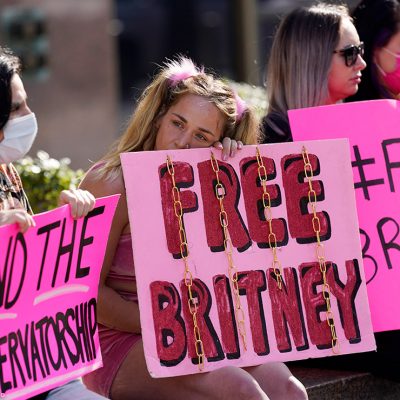 Britney Spears' supporters sit outside holding signs that read "Free Britney" and "End the Conservatorship" during a court hearing concerning the pop singer's conservatorship