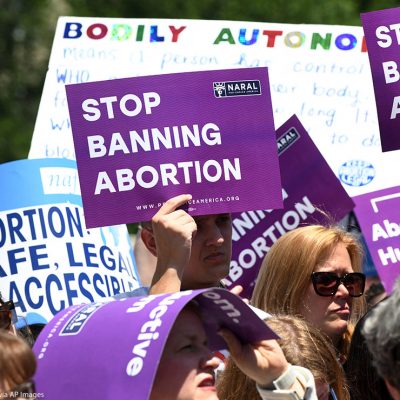 Pro-abortion activists hold placards that read "Stop Banning Abortion" during a rally at the Supreme Court