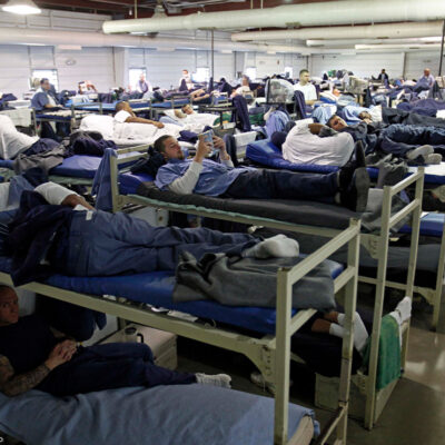 A room full of inmates are seen in their bunk beds