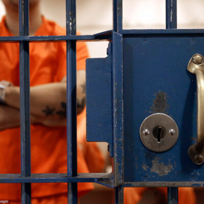 Photo of an inmate behind bars.
