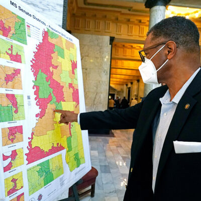 Sen. Sollie Norwood, D-Jackson points out his district on a poster-sized map in the Capitol rotunda in Jackson, Mississippi