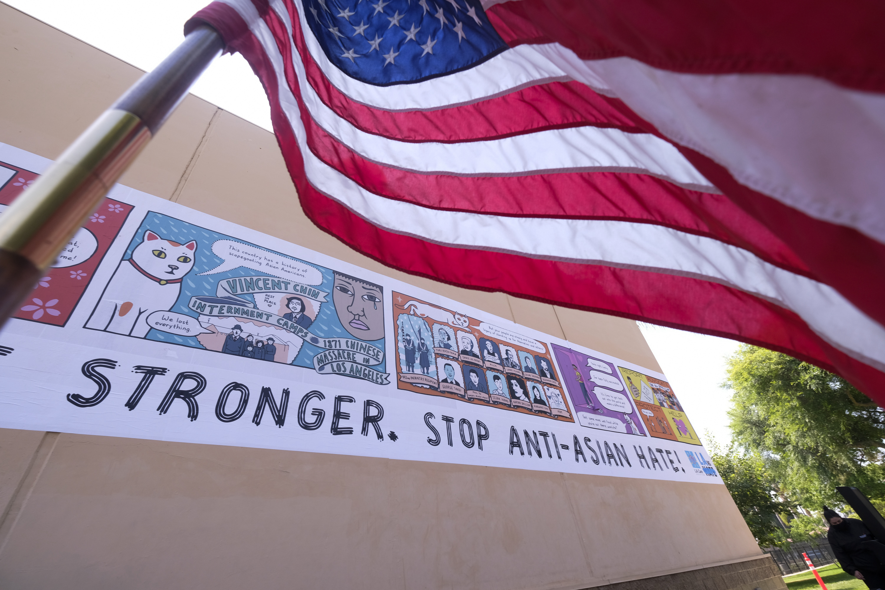 A U.S. flag waves in front of a piece of public artwork about Asian American Pacific Islanders at the Garvey Park in Rosemead.