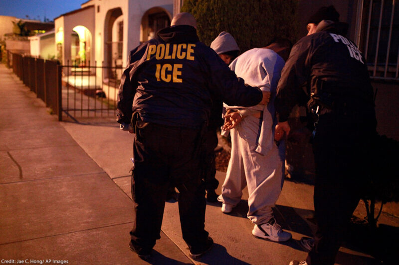 U.S. Immigration and Customs Enforcement (ICE) officers apprehending two men.