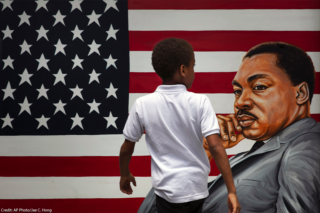 A young boy walks past a painting depicting Dr. Martin Luther King Jr. during a Juneteenth celebration in Los Angeles.