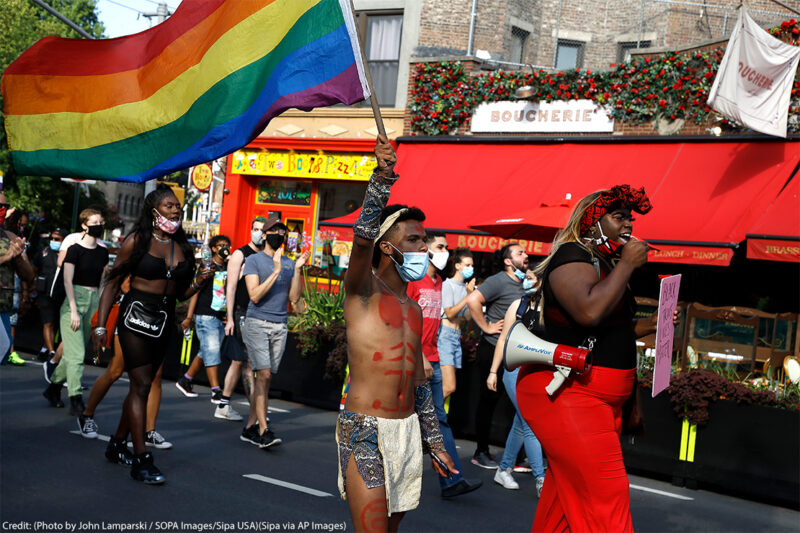 Trans activists march at the Black Transnational Rally with a rainbow flag in the West Village of Manhattan.