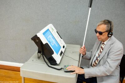 Michael Kasey, who is blind, demonstrates a voting machine that allows people with disabilities to vote.