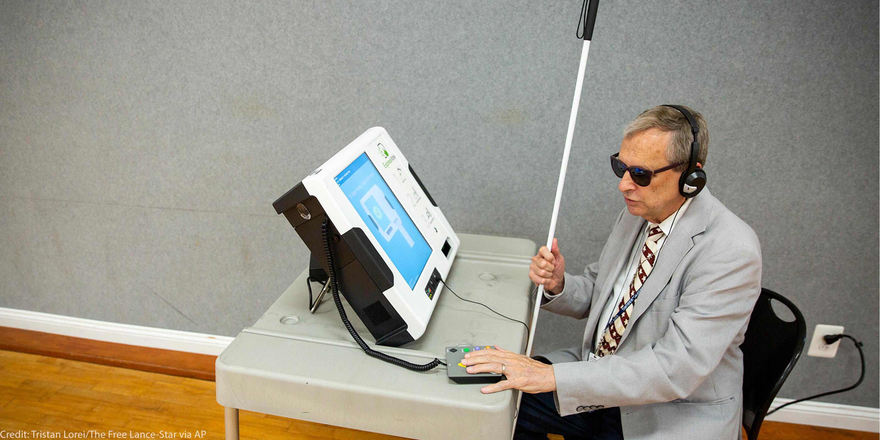 Michael Kasey, who is blind, demonstrates a voting machine that allows people with disabilities to vote.