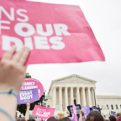 Protesters supporting abortion march in front of the Supreme Court holding signs that read "Bans off our Bodies."