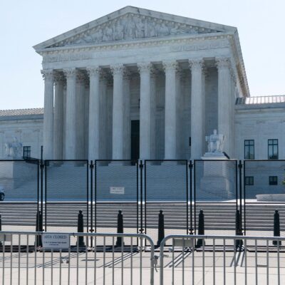 A view front of the U.S. Supreme Court Building behind riot gates.