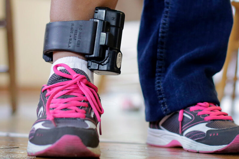 An individual wearing an ankle monitor.