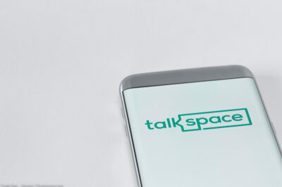 Image of Talkspace app on a smartphone on a white background.