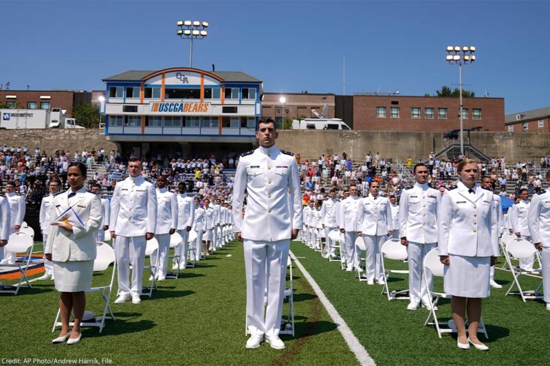 US Coast Guard cadets in white uniforms stand in neat rows at the commencement for the United States Coast Guard Academy in New London, Conn.