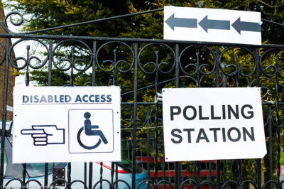 A polling station sign and disabled access sign.