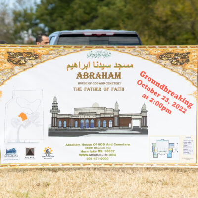 A sign advertising the groundbreaking of Abraham House of God Mosque & Cemetery, with a drawing of a mosque.