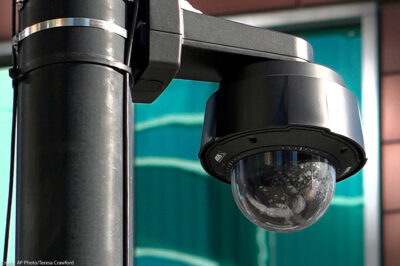 A close-up of a black surveillance camera on a black pole in Chicago.