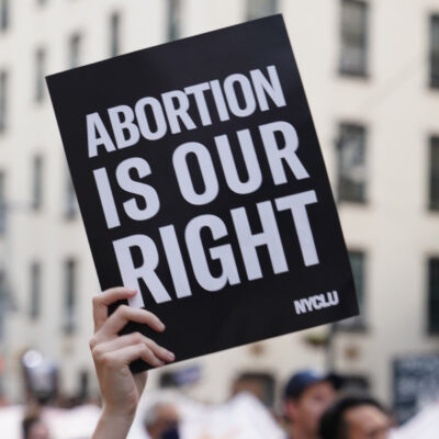 A person holding up a sign saying "Abortion is Our Right."