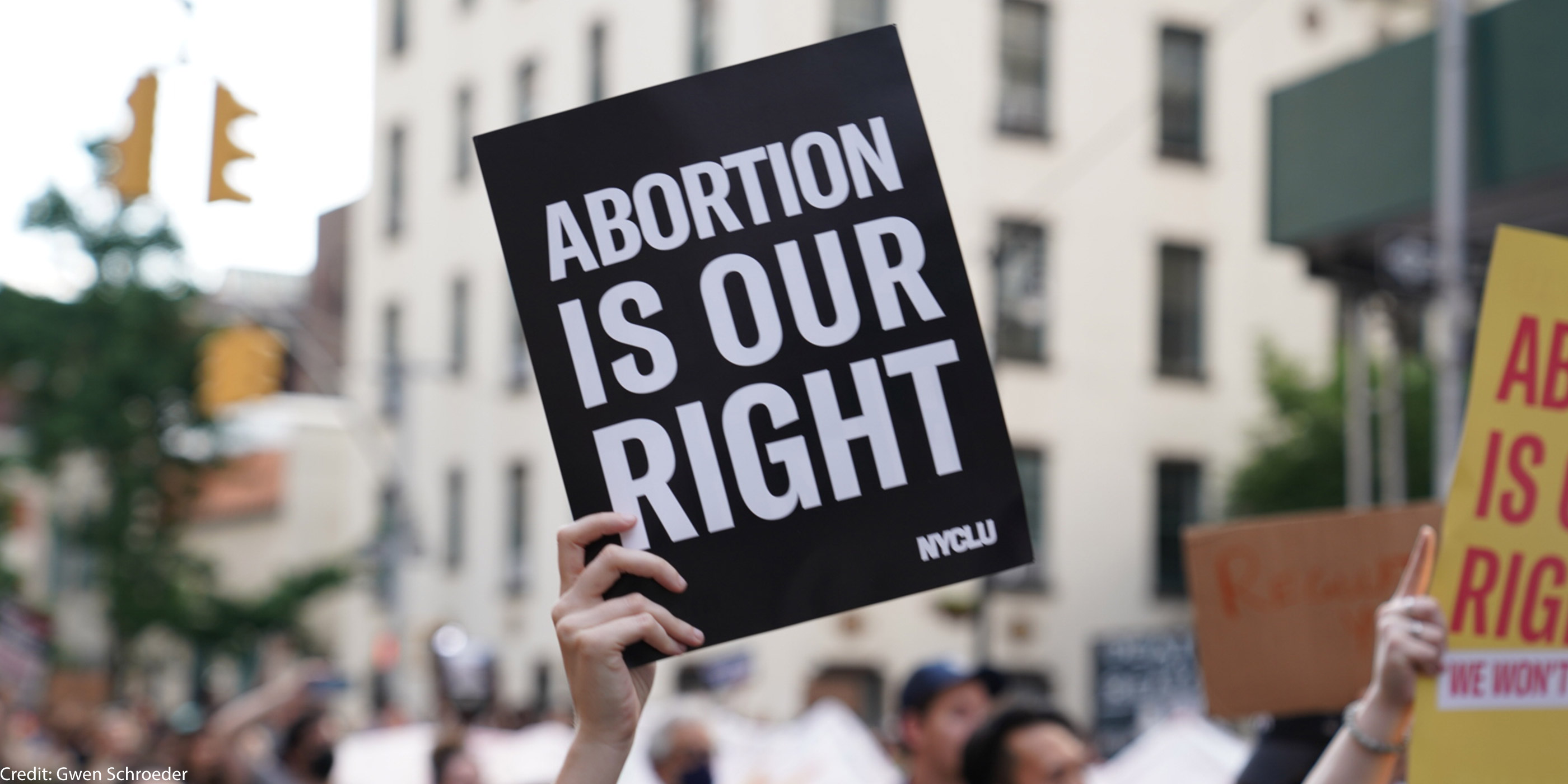 A person holding up a sign saying "Abortion is Our Right."