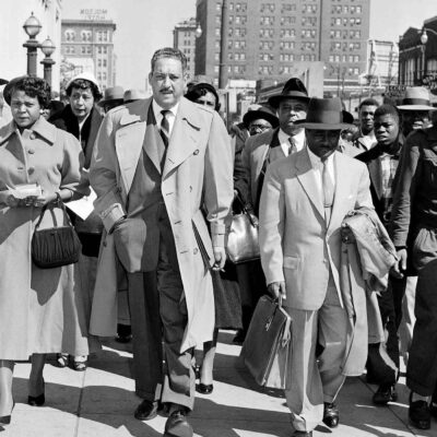 Autherine Lucy, left, front, 26-year-old student at the University of Alabama, arrives at U.S. District Court for the hearing of her petition for an order requiring the school to re-admit her to classes in Birmingham, Ala., Feb. 29, 1956. With Lucy are her legal team, Thurgood Marshall, tall man at center, and Arthur Shores, carrying coat at right.