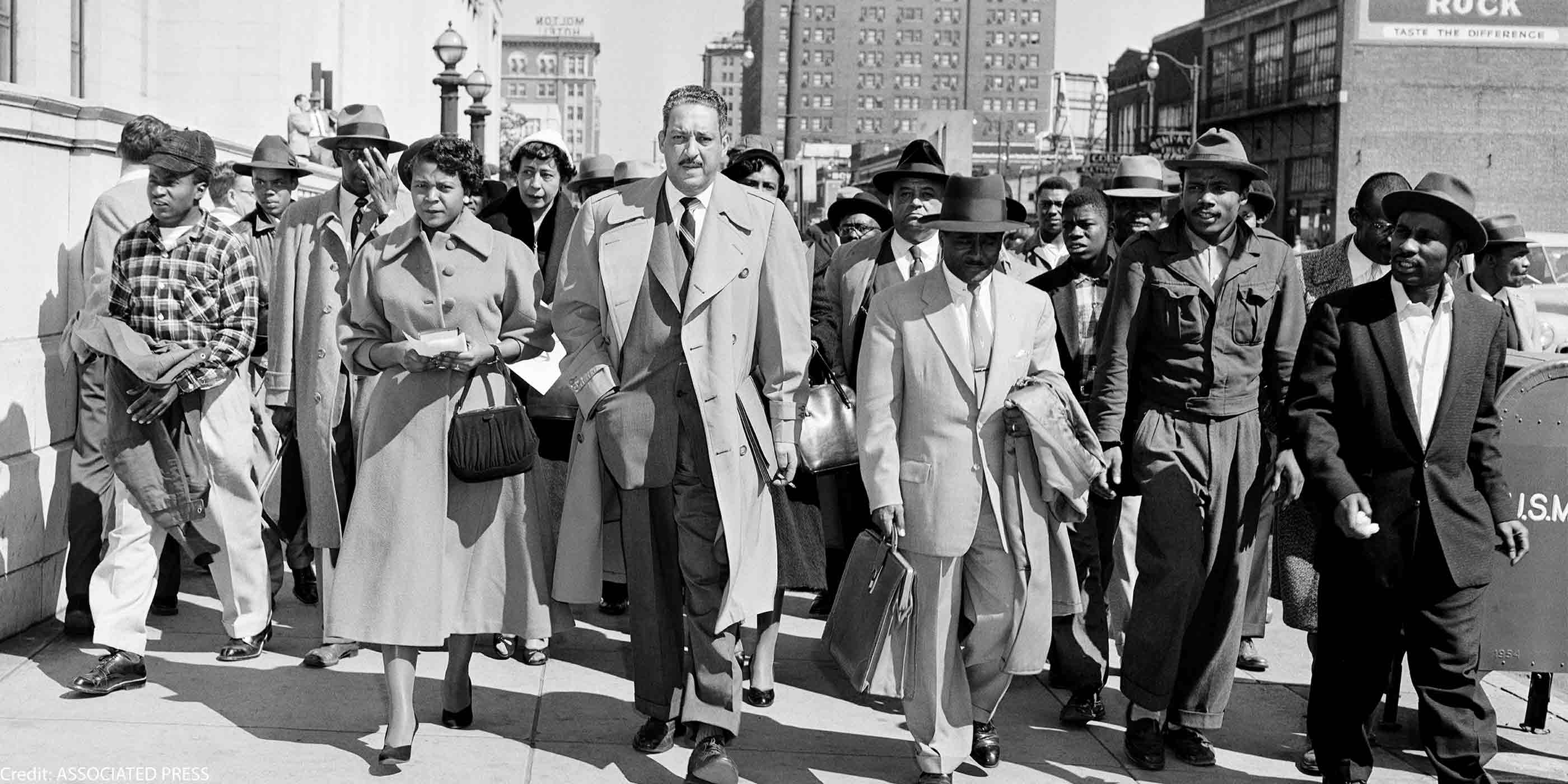 Autherine Lucy, left, front, 26-year-old student at the University of Alabama, arrives at U.S. District Court for the hearing of her petition for an order requiring the school to re-admit her to classes in Birmingham, Ala., Feb. 29, 1956. With Lucy are her legal team, Thurgood Marshall, tall man at center, and Arthur Shores, carrying coat at right.