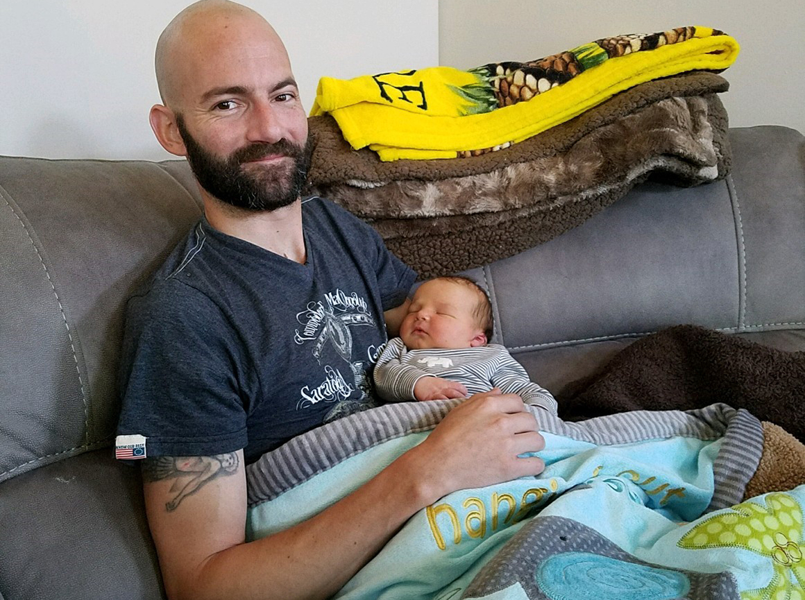 Derek Rotondo and his newborn baby.