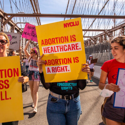 Three demonstrators holding pro-abortion signage.