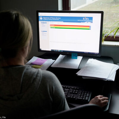 A case work supervisor looks over the first screen of software used by workers who field calls at an intake call screening center for the Allegheny County Children.